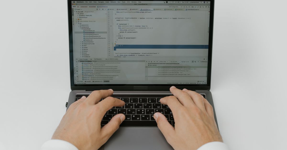 Close-up of hands coding on a laptop, showcasing software development in action.